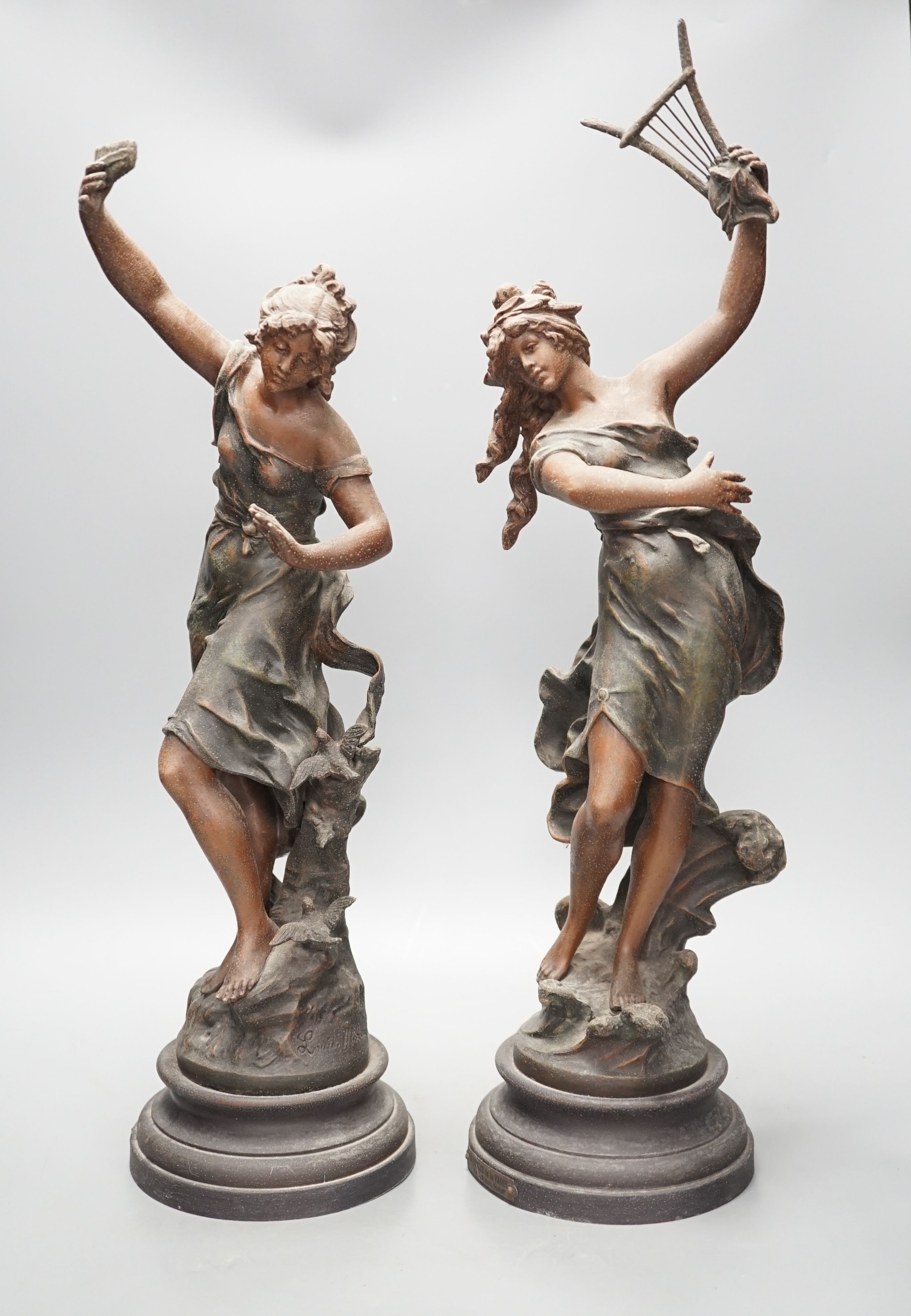 A pair of patinated spelter figures of musical maidens, tallest 58 cms high.